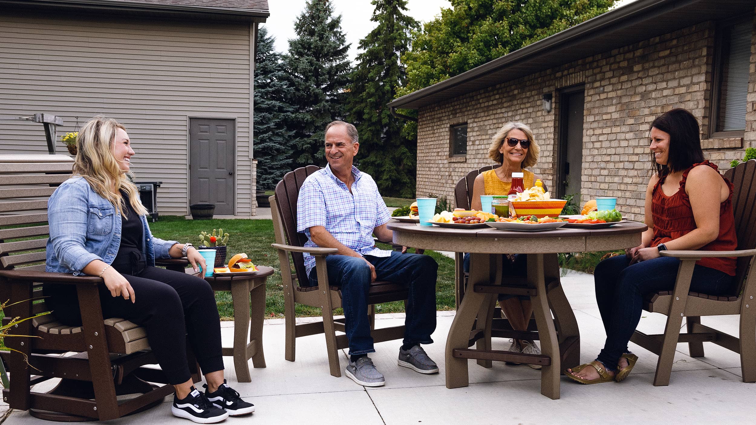A family sitting in Evergreen Outdoor Furniture having a dinner